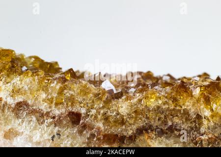 Véritable gros plan macro brillant améthyste traité thermiquement, amas de citrine jaune foncé isolé sur une surface de fond blanc. Fond d'amas de cristaux Banque D'Images