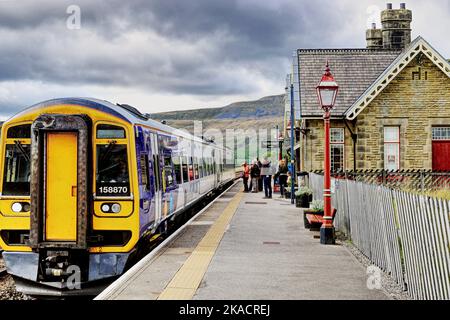 Les passagers font la queue pour monter à bord d'un train à la gare de Ribblehead, sur le plateau de Carlisle Line, Ribble Valley, North Yorkshire, Angleterre, Royaume-Uni Banque D'Images