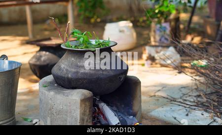 Feuilles de Neem vert connues sous le nom d'Azadirachta indica bouillies dans l'eau sur le chulha. Neem en ébullition, nimtree ou lilas indien sur poêle à argile. Utilisation village indien pour Banque D'Images