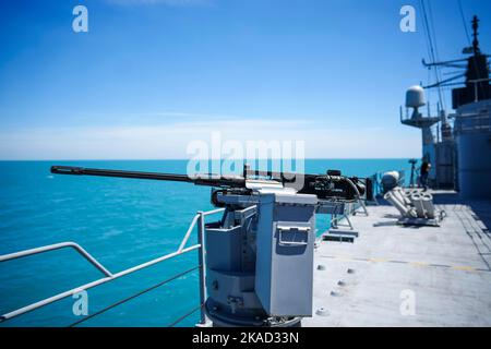 Image couleur d'une mitrailleuse automatique sur le pont d'un navire militaire, en mer. Banque D'Images