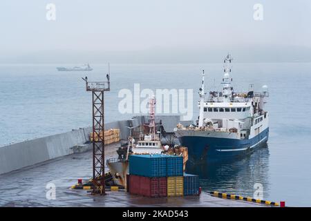 bateau de pêche à la jetée dans le port sur la rive d'une mer trouble Banque D'Images