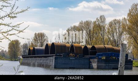 Un gros plan de barges avec des monopiles dans un port industriel de Roermond Banque D'Images