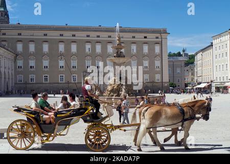 Les touristes apprécient un voyage dans une calèche tirée par des chevaux, la Residenzplatz, Salzbourg, Autriche, Europe Banque D'Images