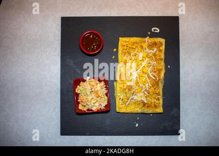 Crêpe remplie de poulet et une petite salade sur le côté Banque D'Images