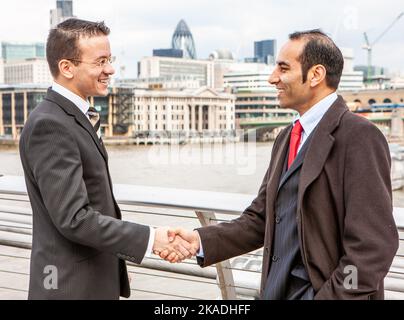 La poignée de main d'affaires de Londres. Un accueil chaleureux et amical entre les hommes d'affaires au bord de la Tamise. À partir d'une série d'images associées. Banque D'Images