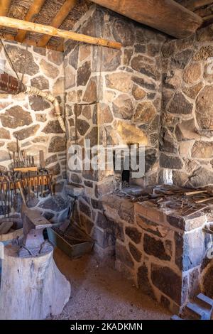 Une enclume, des outils et une forge en pierre dans le magasin de forgeron du Pioneer Cove Creek Ranch fort, construit en 1867, Cove fort, Utah. Banque D'Images