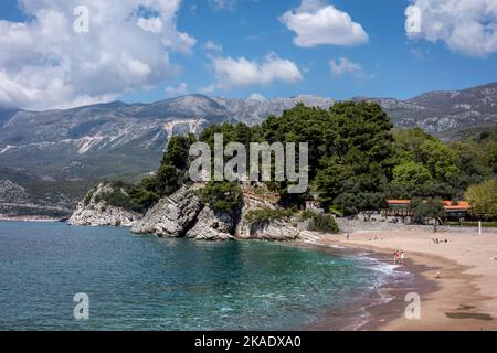 Budva, Monténégro - 28 avril 2022: Côte Adriatique dans la région de Budva. Plage de sable, eau de mer turquoise, bâtiments d'hôtel et montagnes en arrière-plan. Banque D'Images