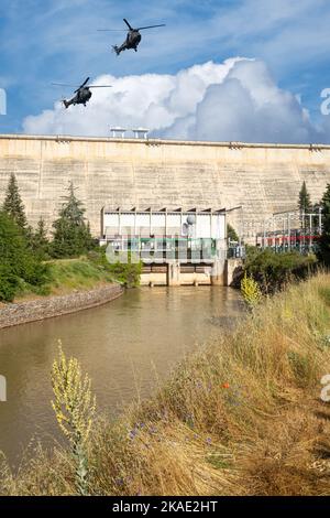 Hélicoptères militaires survolant un barrage hydro-électrique. Image conceptuelle : attaque militaire contre l'énergie de l'Ukraine, infrastructure énergétique, Russie, conflit, guerre. Banque D'Images