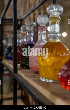 Un cliché vertical de quelques bouteilles en verre remplies de liquides colorés Banque D'Images