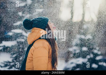 Photo de funky ludique écolière porter veste coupe-vent levant langue dégustation chute de neige campagne forêt Banque D'Images