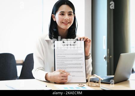 l'agent immobilier donne un accord entre le stylo et les documents avec le client pour signer le contrat. Accord de concept. Banque D'Images