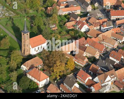 VUE AÉRIENNE. Église protestante surplombant la rue principale avec ses maisons à colombages uniques. Hunspach, Bas-Rhin, Alsace, Grand est, France. Banque D'Images