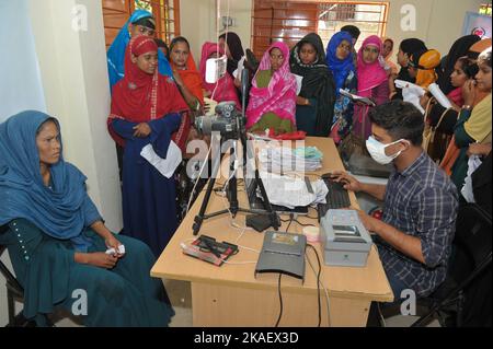 Sylhet, Bangladesh. 02nd novembre 2022. Un personnel de la commission électorale scanne l'iris d'un électeur au cours D'Un grand nombre de personnes qui attendent dans une file d'attente et fournit des données dans le bureau de l'UNO de Sylhet Companiganj alors que la commission électorale collecte des informations sur les personnes pour mettre à jour sa nouvelle liste électorale. On 2 novembre 2022 (Credit image: © MD Rafayat Haque Khan/eyepix via ZUMA Press Wire) Banque D'Images