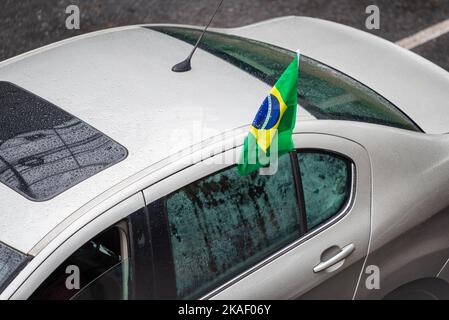 Voiture blanche avec drapeau brésilien sur la fenêtre à Belo Horizonte, Brésil. Banque D'Images