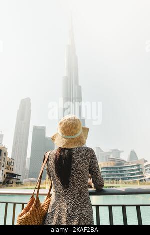 Dubaï, Émirats Arabes Unis - 11th octobre 2022 : touriste moderne, femme qui regarde la tour de Burj Khalifa contre un ciel blanc trouble, Dubaï, Émirats Arabes Unis Banque D'Images