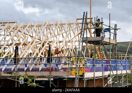 Pontypridd, pays de Galles - octobre 2022 : ouvriers de la construction travaillant sur le toit de maisons en cours de construction sur un nouveau développement de logements par Bellway Homes Banque D'Images