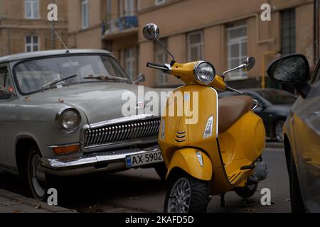 Jaune Vespa Elettrica scooter électrique garée dans la rue entre les voitures Banque D'Images