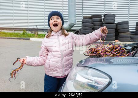 Happy Girl travaille dans un garage de voiture d'un centre de service de voiture. Concept de réparation automatique Banque D'Images