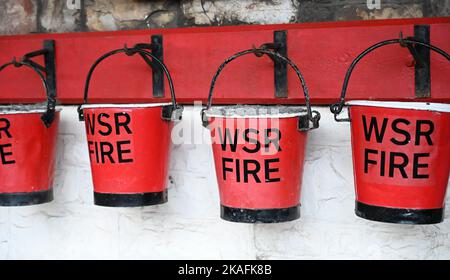 Seaux à feu rouges suspendus sur un mur Banque D'Images