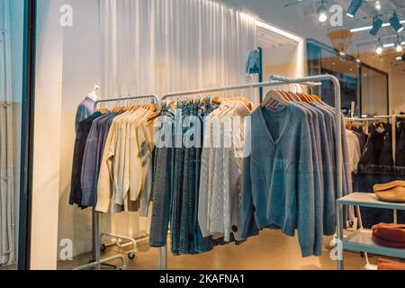 Hommes vêtements décontractés sur les étagères et les cintres dans un magasin de centre commercial. Une pile de vestes dans un centre commercial. Présentoir de tablettes dans un centre commercial. Banque D'Images