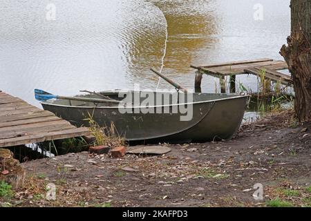 Un bateau en métal avec des oars sur la rive du lac. Bateau de pêcheur. Banque D'Images