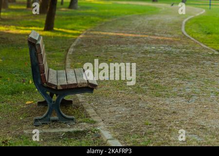 Banc vide dans le parc automnal avec chemin, aire de repos loin du bruit de la ville Banque D'Images