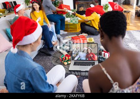 Divers amis avec des décorations de noël ayant des appels vidéo avec heureux divers couple Banque D'Images