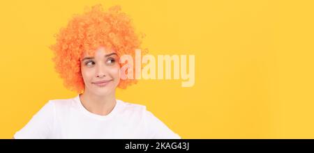 Femme isolé visage portrait, bannière avec espace de copie. Sensation de flirté. Femme gaie femme porte perruque. Femme a des cheveux orange. Étant un clown. avril Fools jour. Banque D'Images