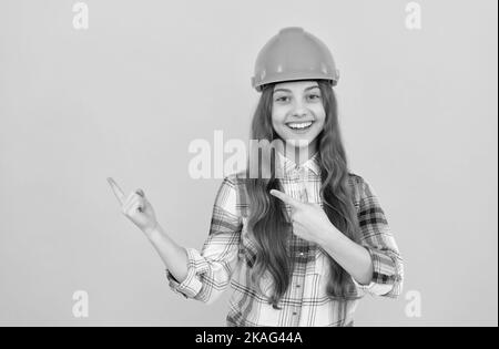 jeune fille dans un casque. enfant de constructeur dans une chemise à carreaux. concept de construction et de construction. Banque D'Images