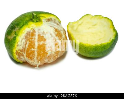 Mandarine non mûre. Éplucher une mandarine. Fruit vert sur fond blanc. Ingrédient acide. Isolat d'agrumes. Fruits utiles. Banque D'Images