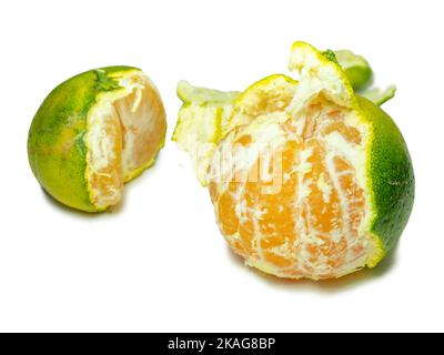 Mandarine non mûre. Éplucher une mandarine. Fruit vert sur fond blanc. Ingrédient acide. Isolat d'agrumes. Fruits utiles. Banque D'Images