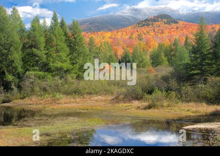 Automne dans les White Mountains du New Hampshire. Vue panoramique sur les feuillages d'automne et la Franconia Notch avec dépoussiérage de neige au sommet du Mont Lafayette. Banque D'Images