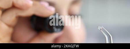 Bijoutier examiner le diamant poli à travers la loupe, bijoux de diamant en cours de classement Banque D'Images