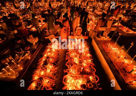 Tombes bien décorées avec des fleurs et des bougies allumées pendant la journée de tous les âmes. Les dévotés chrétiens se rassemblent aux tombes de leurs proches dans un cimetière avec des bougies et des fleurs illuminées pendant la journée des All Souls' Day. Un jour où les chrétiens se souviennent de leurs amis et de leurs proches, qui sont morts. Cela vient d'une croyance ancienne que les âmes des morts reviendront, ce jour-là, pour avoir un repas avec leur famille et leurs amis. Des bougies sont allumées pour guider les âmes vers leur maison pour le repas. (Photo par Avishek Das/SOPA Images/Sipa USA) Banque D'Images