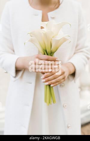 Délicat bouquet blanc de nénuphars aux mains de la mariée au mariage Banque D'Images