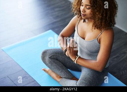 Vous n'avez pas besoin de thérapie, vous avez besoin de yoga. Une jeune femme pratiquant le yoga en studio. Banque D'Images