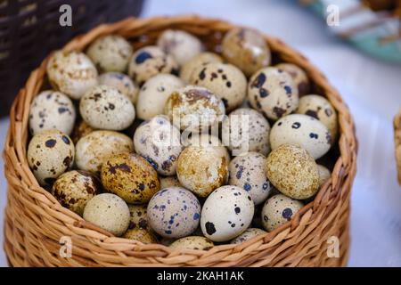 De dessus bouquet d'oeufs de caille frais placés dans le panier en osier sur le marché stall Banque D'Images