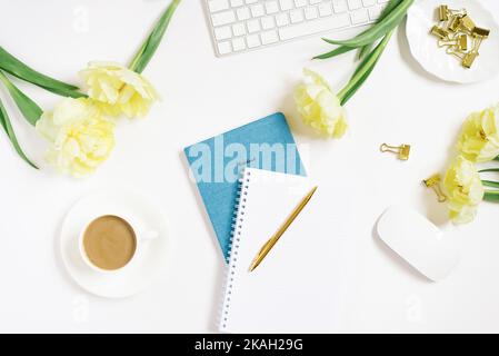 Espace de travail d'un bureau sur fond blanc. L'emplacement d'un lieu de travail féminin dans un bureau avec un clavier d'ordinateur, des fleurs, une souris, un Banque D'Images