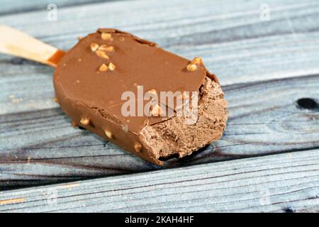 Bâton de glace au chocolat enrobé et recouvert d'une couche de chocolat noir avec des noix, de glace riche aromatisée dans le craquant au chocolat brun et Banque D'Images