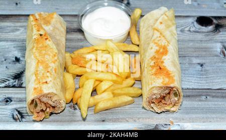 Recettes syriennes cuisine fond, poulet shawerma ou châtarma tortilla envelopper avec oignon, tomate, laitue et sauce à l'ail dans du pain syrien avec potatoe Banque D'Images