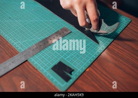 Tanner femme coupant des articles en cuir sur l'atelier.Processus de travail de l'artisan du cuir. Banque D'Images