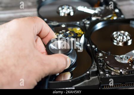 Un stéthoscope médical sur les plateaux HDD et le moteur de l'axe, disque dur démonté composants endommagés, maintenance de l'ordinateur, exécution des diagnostics, r Banque D'Images