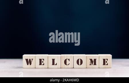 Le mot DE BIENVENUE est écrit sur une structure en cubes en bois. Cube sur un arrière-plan lumineux. Peut être utilisé pour les affaires, LA MÉDECINE, le concept financier. Sélectif Banque D'Images