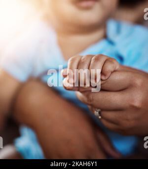 De précieuses petites mains. Portrait d'un petit garçon méconnaissable assis sur ses genoux tout en regardant dans l'appareil photo à la maison pendant la journée. Banque D'Images