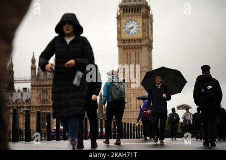 Navetteurs avec parasols le matin pluvieux à Westminster, Londres. Date de la photo: Jeudi 3 novembre 2022. Banque D'Images