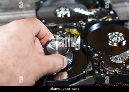 Un stéthoscope médical sur les plateaux HDD et le moteur de l'axe, disque dur démonté composants endommagés, maintenance de l'ordinateur, exécution des diagnostics, r Banque D'Images