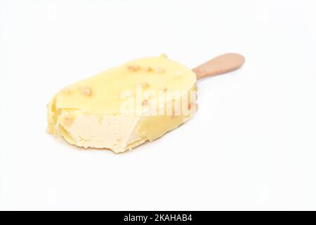 Bâton de glace à la vanille enrobé et recouvert d'une couche de chocolat blanc avec des noix, glace riche aromatisée à la vanille en chocolat blanc craquant et Banque D'Images