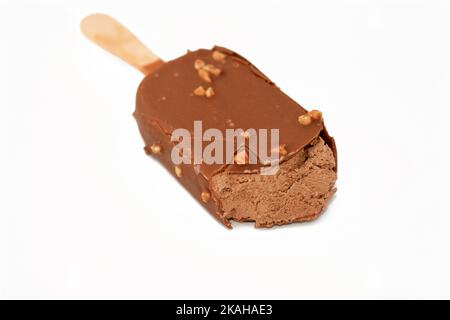 Bâton de glace au chocolat enrobé et recouvert d'une couche de chocolat noir avec des noix, de glace riche aromatisée dans le craquant au chocolat brun et Banque D'Images