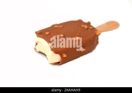 Crème glacée riche à la vanille dans le chocolat au lait brun craquant et l'amande rôtie isolée, bâton de glace à la vanille enrobé et recouvert d'une couche Banque D'Images