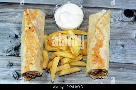 Recettes syriennes cuisine fond, poulet shawerma ou châtarma tortilla envelopper avec oignon, tomate, laitue et sauce à l'ail dans du pain syrien avec potatoe Banque D'Images